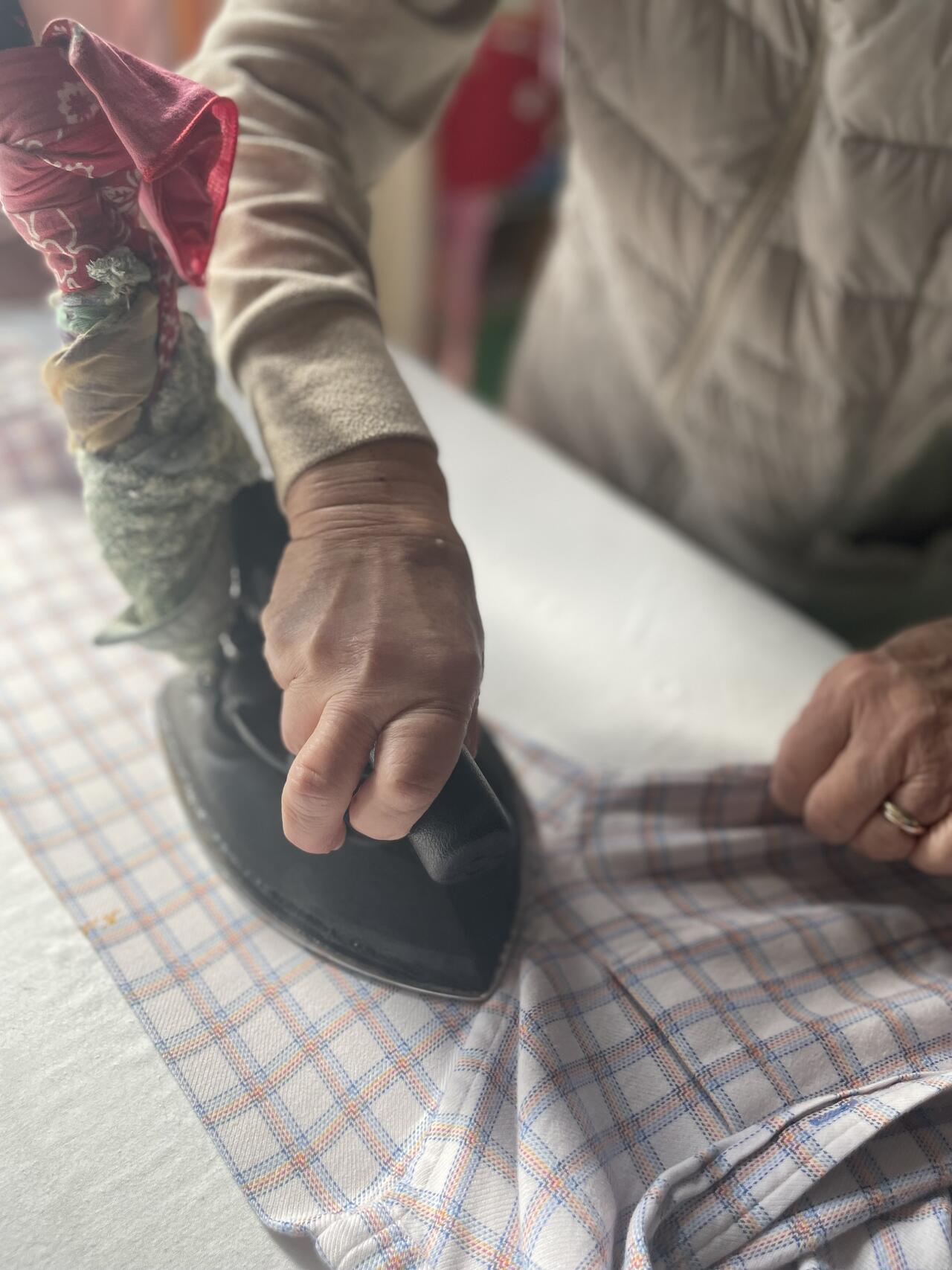 職人がジャケットのラペルを丁寧に手アイロンで仕上げている